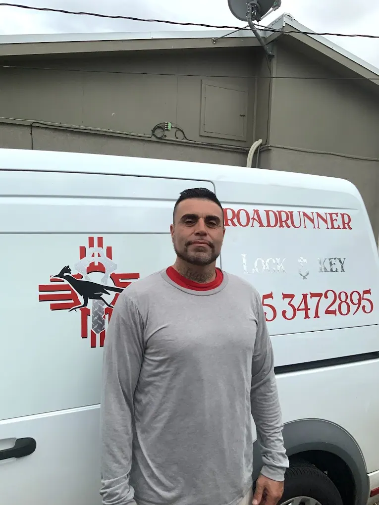 Genaro, owner of Roadrunner Lock and Key, standing in front of a company van