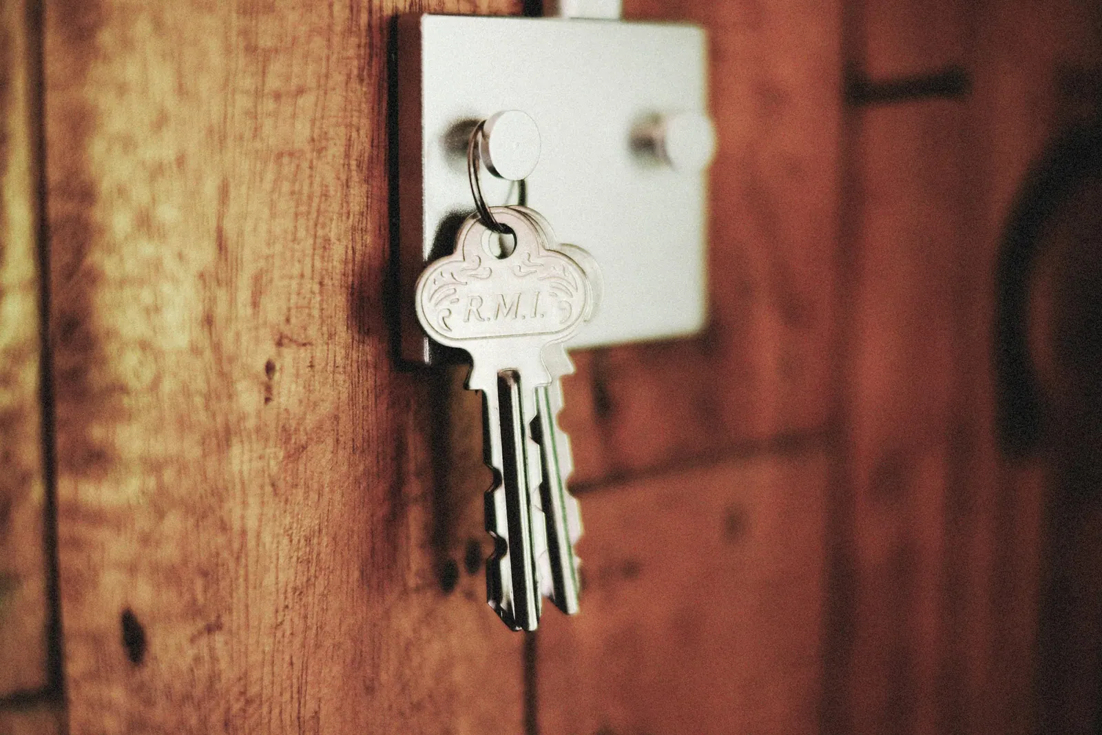 Keys hanging from a lock box on a weathered wooden door